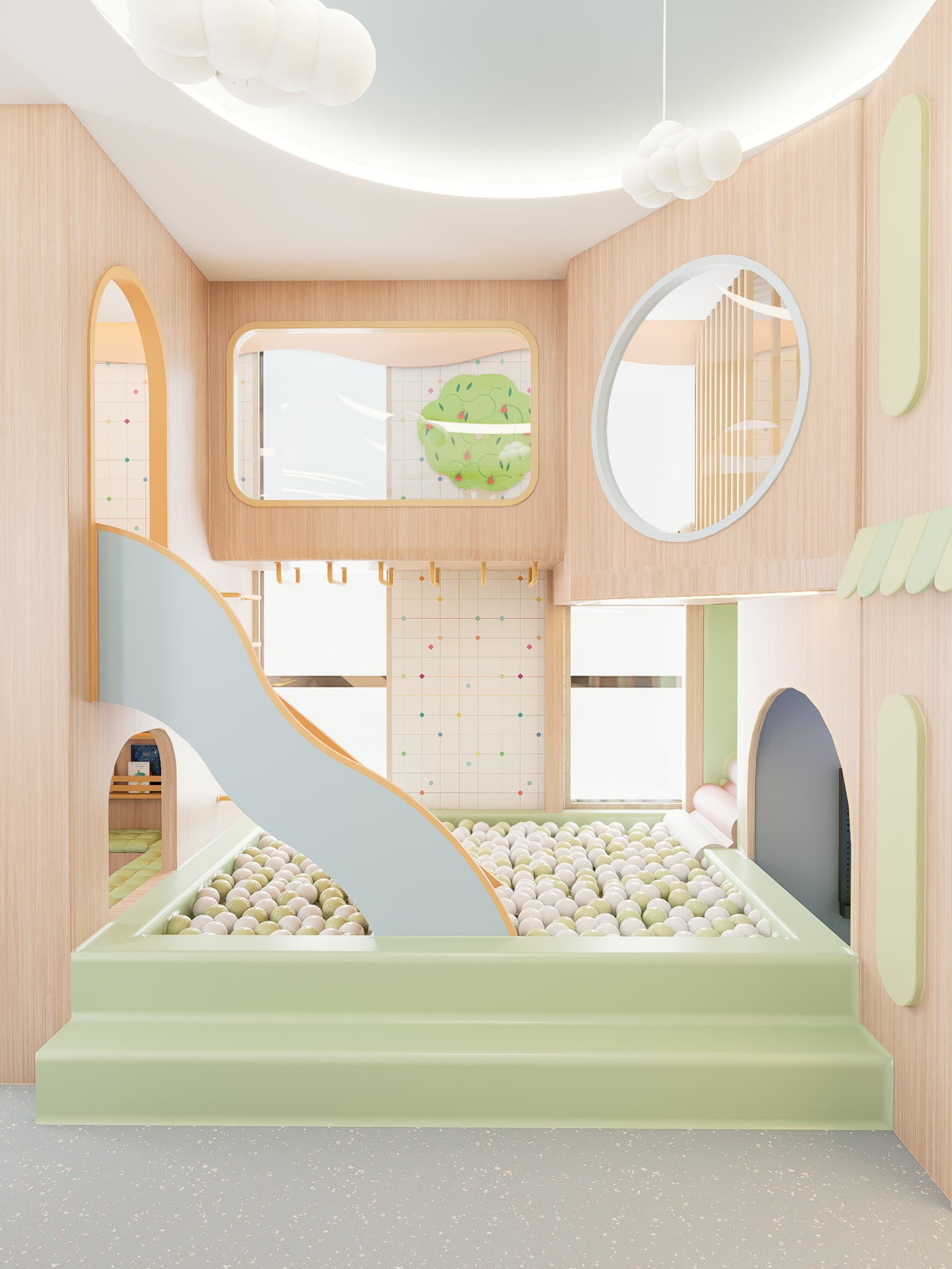 The ball pit at Lyfe Playhouse, with a curved slide coming down into it from the upper level and a climbing wall of coloured pegs on the wall behind.